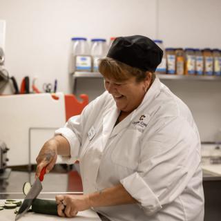 A chef chopping vegetables in a professional kitchen.