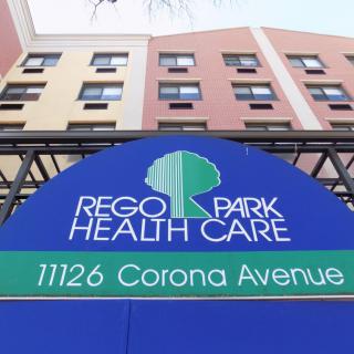 Entrance signage of Rego Park Health Care with building facade in the background.