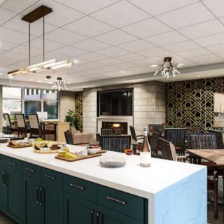 A modern kitchen and dining area featuring an island counter with seating, stylish lighting fixtures, and elegant decor.