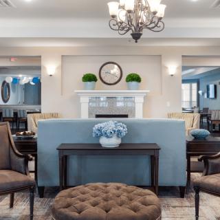A beautifully decorated living room featuring a classic and elegant interior design with a chandelier, sofa, and stylish furnishings.