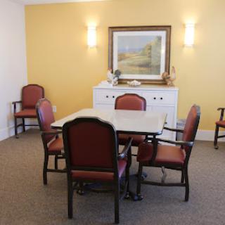 A cozy dining room setup with a wooden table and seating in a warm yellow space.