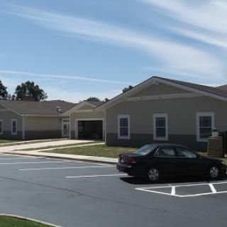 A view of a suburban residential area with several buildings and a parked car.