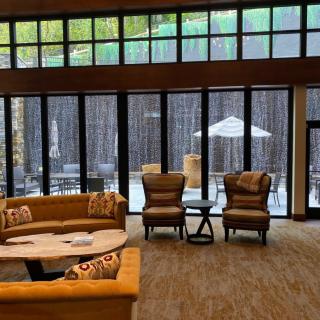 A cozy lounge area with large windows offering natural light and comfortable seating.