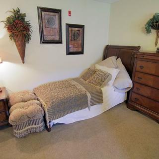Cozy bedroom with a single bed and classic wooden furniture.