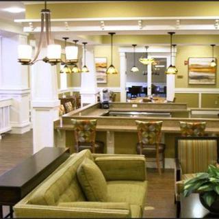 A modern lounge area featuring green sofas and stylish lighting.