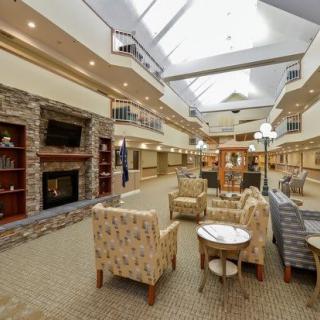 A spacious lobby area with comfortable seating, a fireplace, and a large skylight overhead.