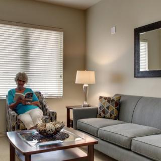 A woman sitting in a cozy living room reading a book.