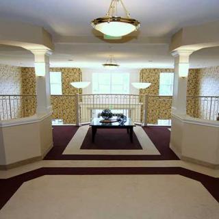 Elegant lobby with chandeliers and a balcony overlooking the space.