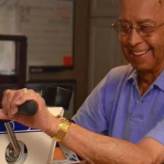 A person smiling while operating a machine indoors.