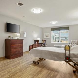 Modern and well-furnished hospital room with a single bed, television, and window.