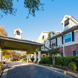 A residential building with a covered entrance and well-maintained landscaping.