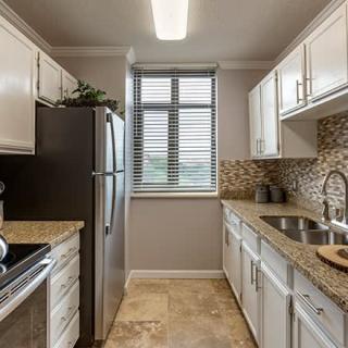 A modern kitchen with white cabinets and stainless steel appliances.