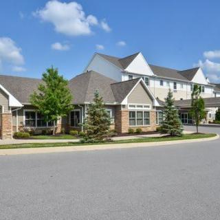 A suburban residential building with landscaped surroundings on a sunny day.
