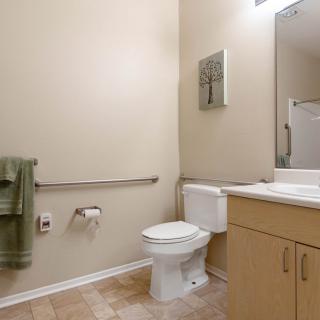 A clean and modern bathroom with a toilet, sink, and mirror.