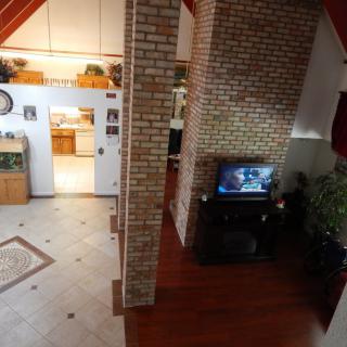 A cozy open-layout home interior featuring a living room with a television and a visible kitchen area.