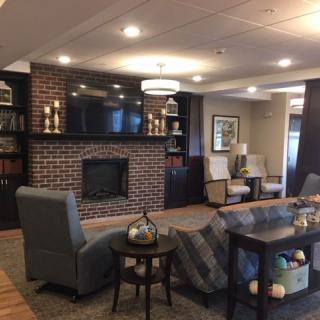 A modern living room with a brick fireplace and comfortable seating.