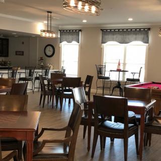 A cozy dining and recreational space with tables, chairs, and a pool table.