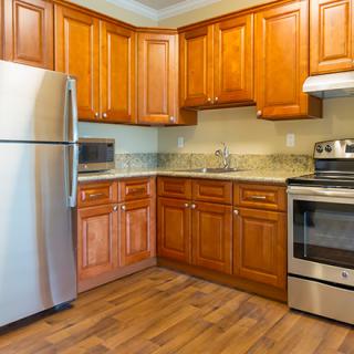 Modern kitchen with wood cabinets and stainless steel appliances.