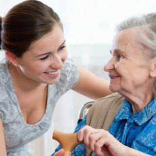 A young woman interacting with an elderly woman, showcasing warm companionship and support.