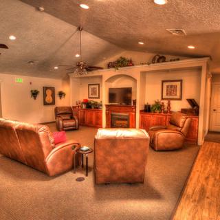 A cozy living room with sofas, a fireplace, and a television.