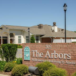 The Arbors, a retirement living facility with a welcoming entrance and landscaped grounds.