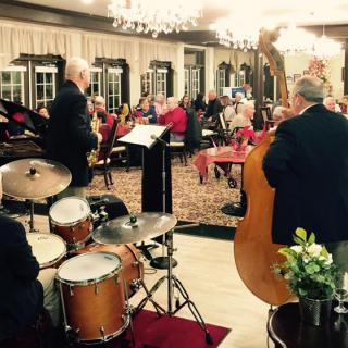 A jazz band performs live in a restaurant setting with an attentive audience.