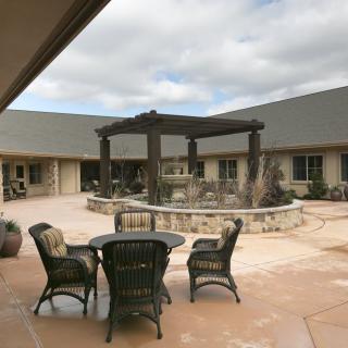 A serene courtyard with outdoor seating and a central pergola structure.