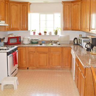 A spacious kitchen with wooden cabinets and modern appliances.
