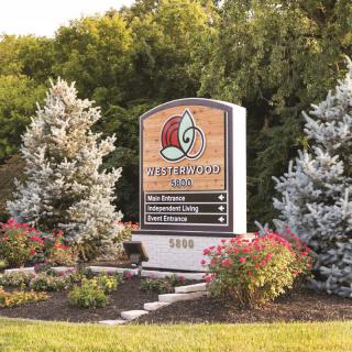 Entrance sign to Phillips Park surrounded by landscaped greenery and flowers.
