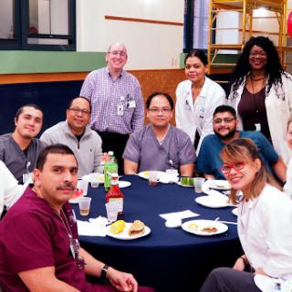 A group of healthcare professionals enjoying a meal together in their breakroom.