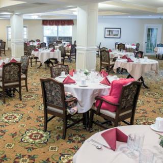 A well-arranged dining room with neatly set tables and chairs, ready for guests.