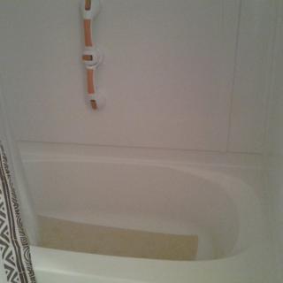 A bathroom with a partially filled bathtub.
