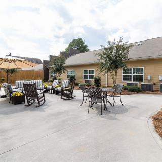 A spacious patio with seating and umbrellas in a backyard setting.