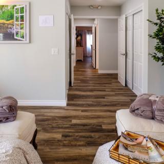 A cozy interior hallway with wood flooring and comfortable seating.