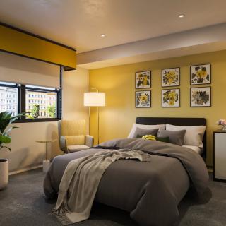 A cozy modern bedroom with yellow walls and stylish decor.