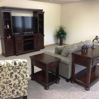 A cozy living room setup featuring a TV stand, couch, and coffee table.