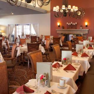 An elegant restaurant interior with neatly arranged dining tables and warm lighting.
