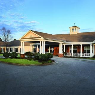 A welcoming residential facility with a spacious front entrance and well-maintained landscaping.