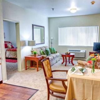 A cozy living space featuring a small dining area, comfortable sofa, and adjoining bedroom.