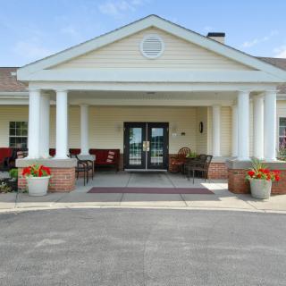 A building entrance with columns and potted flowers.