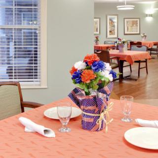 A beautifully set dining table with a colorful floral arrangement, creating a warm and inviting atmosphere.
