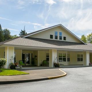 A one-story building with a large entrance and surrounding greenery.