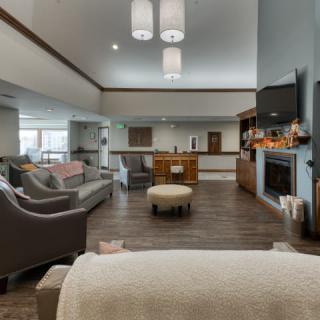 A cozy and spacious living room with modern furniture, a fireplace, and a mounted television.