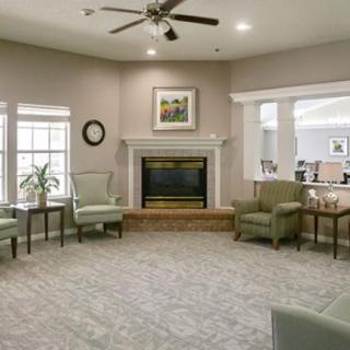 A cozy living room with a fireplace, armchairs, and soft lighting.