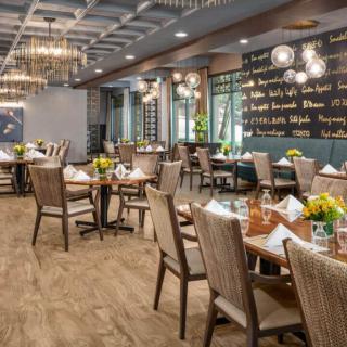 A beautifully decorated restaurant dining area with neatly arranged tables and elegant chandeliers.