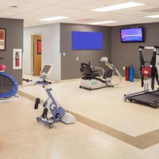 A modern gym with various exercise equipment including a treadmill and stationary bikes.