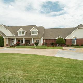A large suburban house with a well-maintained lawn and driveway.