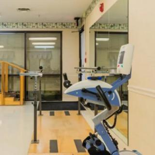 A rehabilitation exercise room featuring a stationary bike and mirrors.