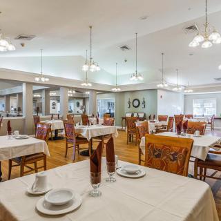 A spacious restaurant dining room with elegantly set tables and comfortable seating.