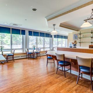 A spacious lounge area featuring a bar and comfortable seating with ample natural light.